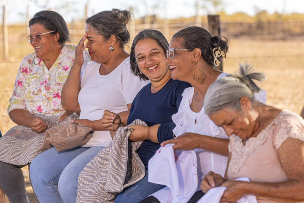 Urucuia: bordadeiras sorridentes trabalham juntas ao ar livre