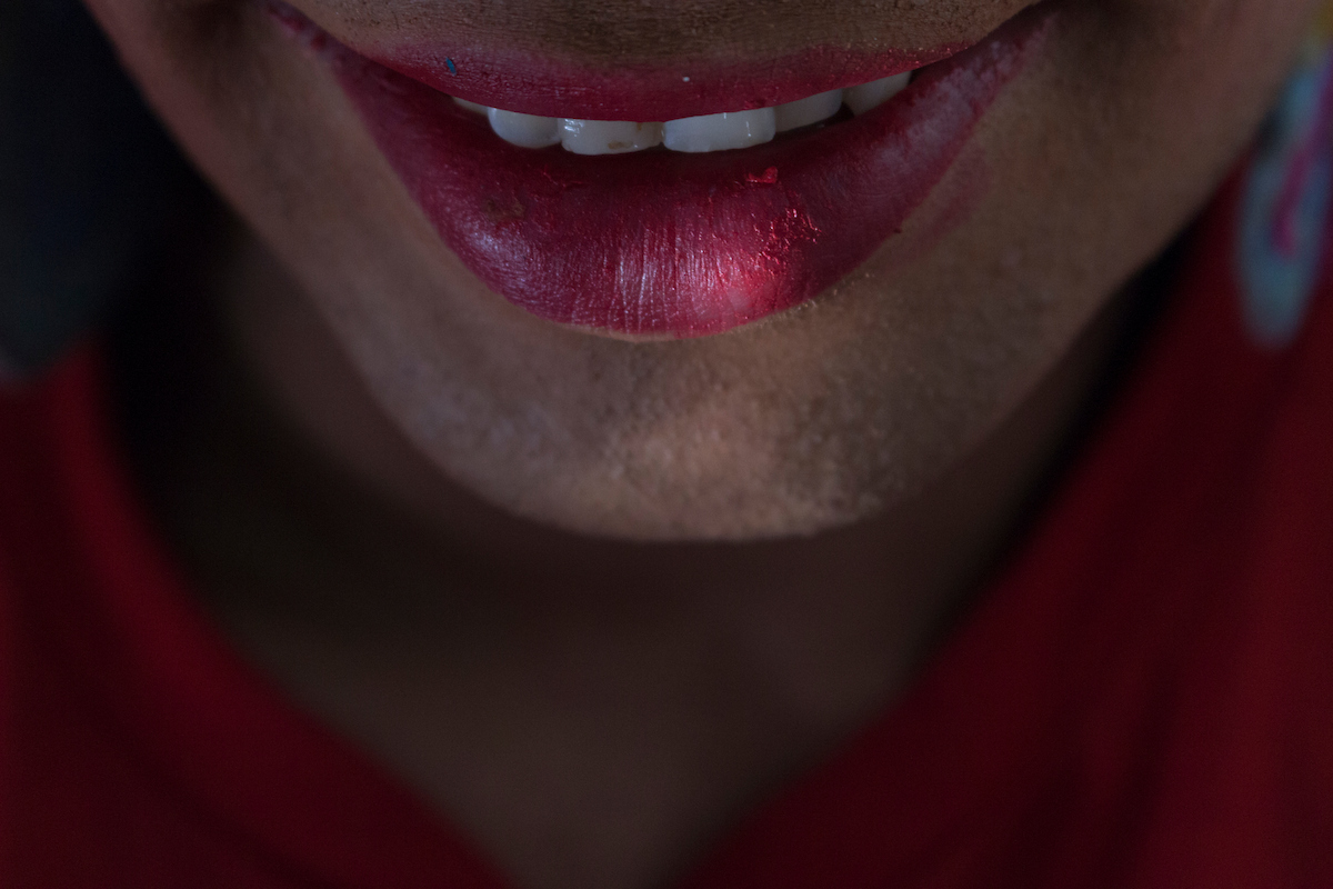 A Estrela: close do sorriso de participante de batom vermelho