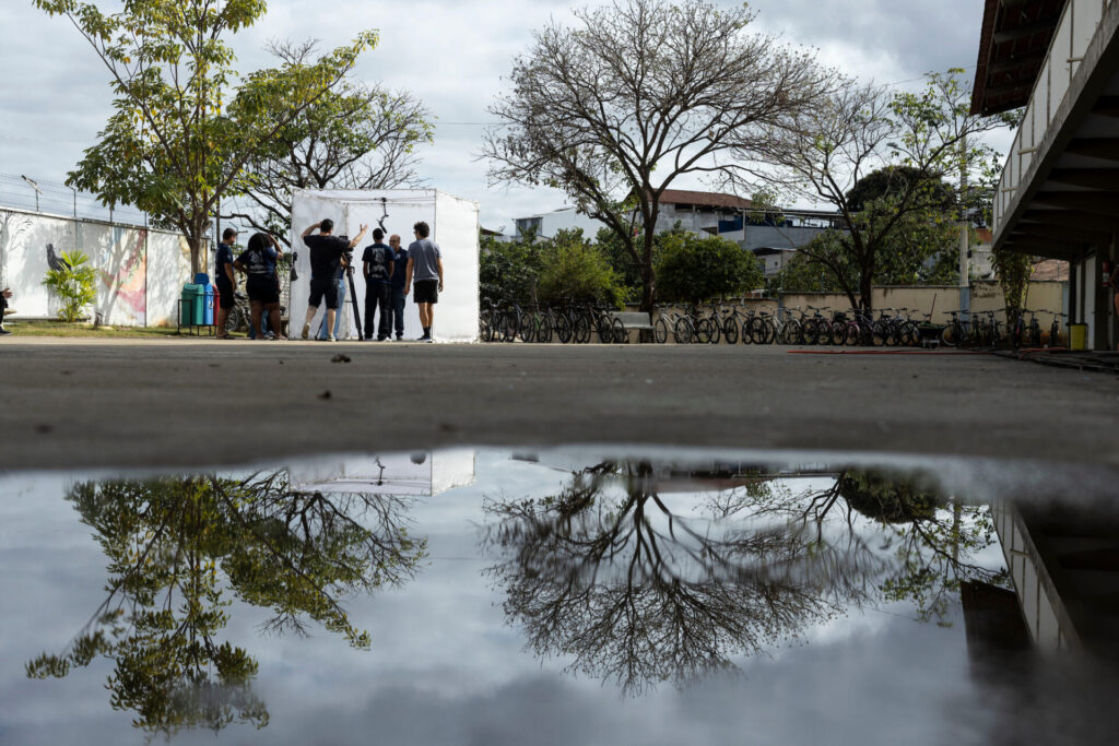 Moradores Educação: estúdio no pátio da escola refletido em poça d'água