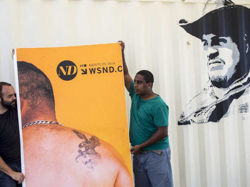 ND: participantes seguram banner diante de mural com retrato