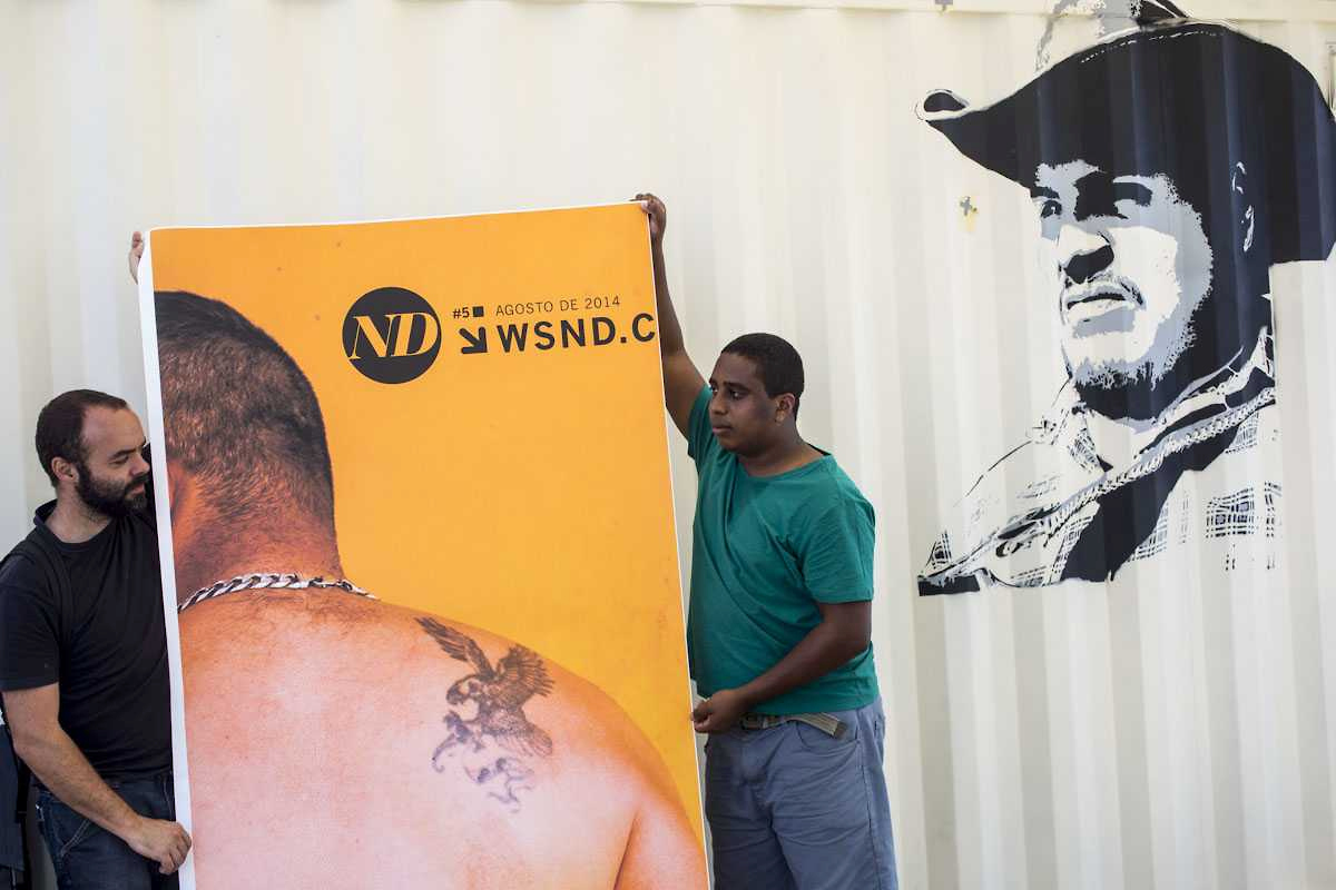 ND: participantes seguram banner diante de mural com retrato