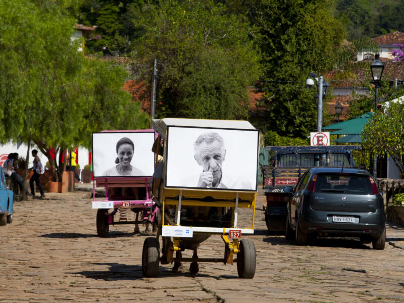 Projeto Moradores em Tiradentes: retratos expostos em charretes nas ruas de pedra