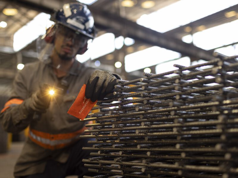 Trabalhador com lanterna inspeciona telas de aço na Trefilaria da ArcelorMittal em São Paulo