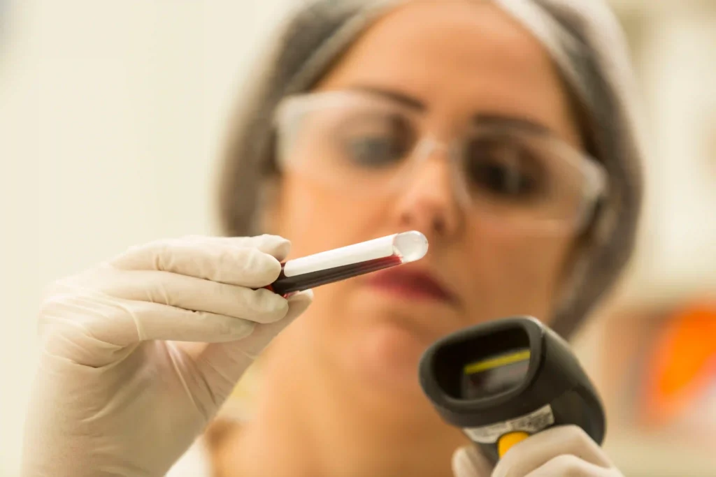 Unimed: profissional de laboratório com óculos de proteção analisa tubo de amostra