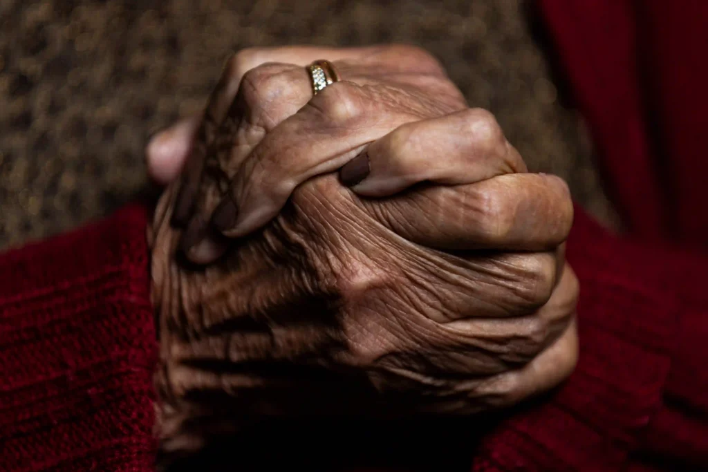 Centenários: mãos entrelaçadas de uma mulher centenária