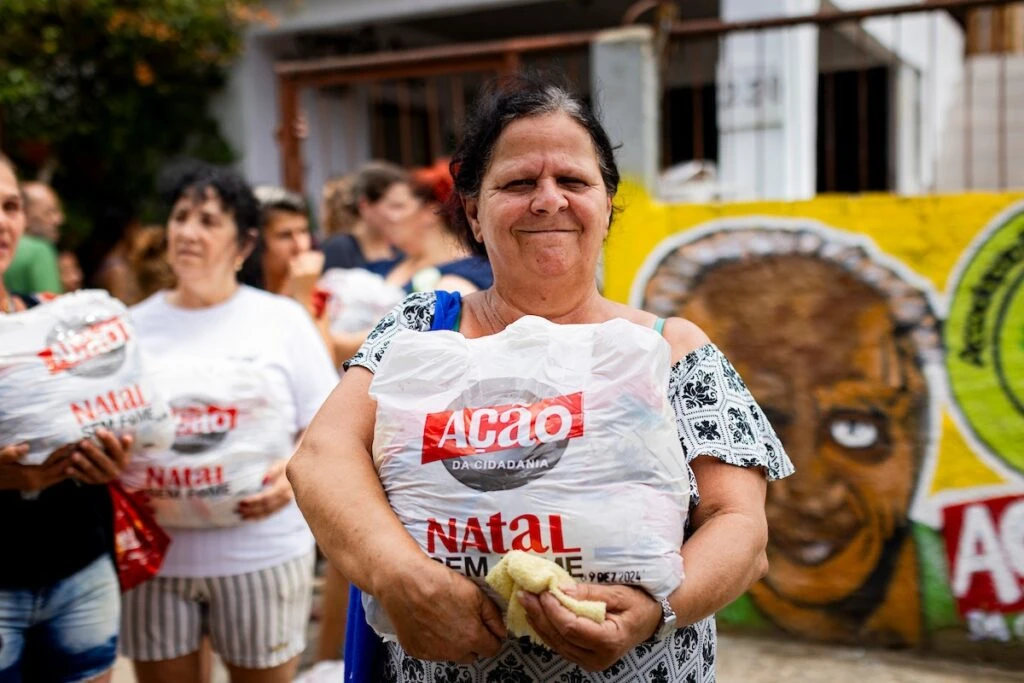 Ação da Cidadania, Natal Sem Fome: mulher sorridente segura sacola de doação