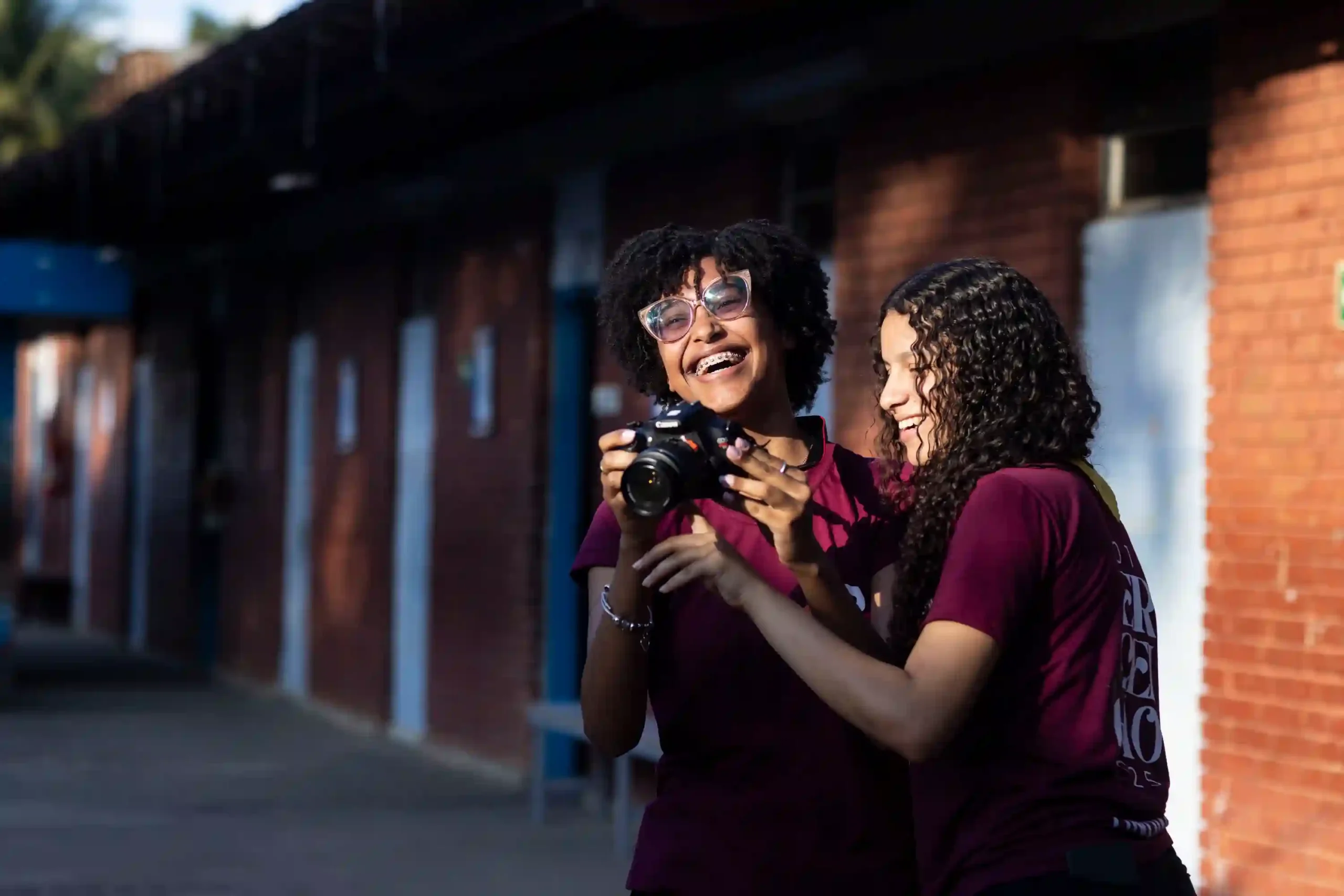 Moradores Educação: estudantes sorridentes conferem foto na câmera