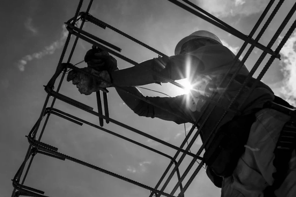Relatório MRV&CO: operário monta armação de ferro contra o sol
