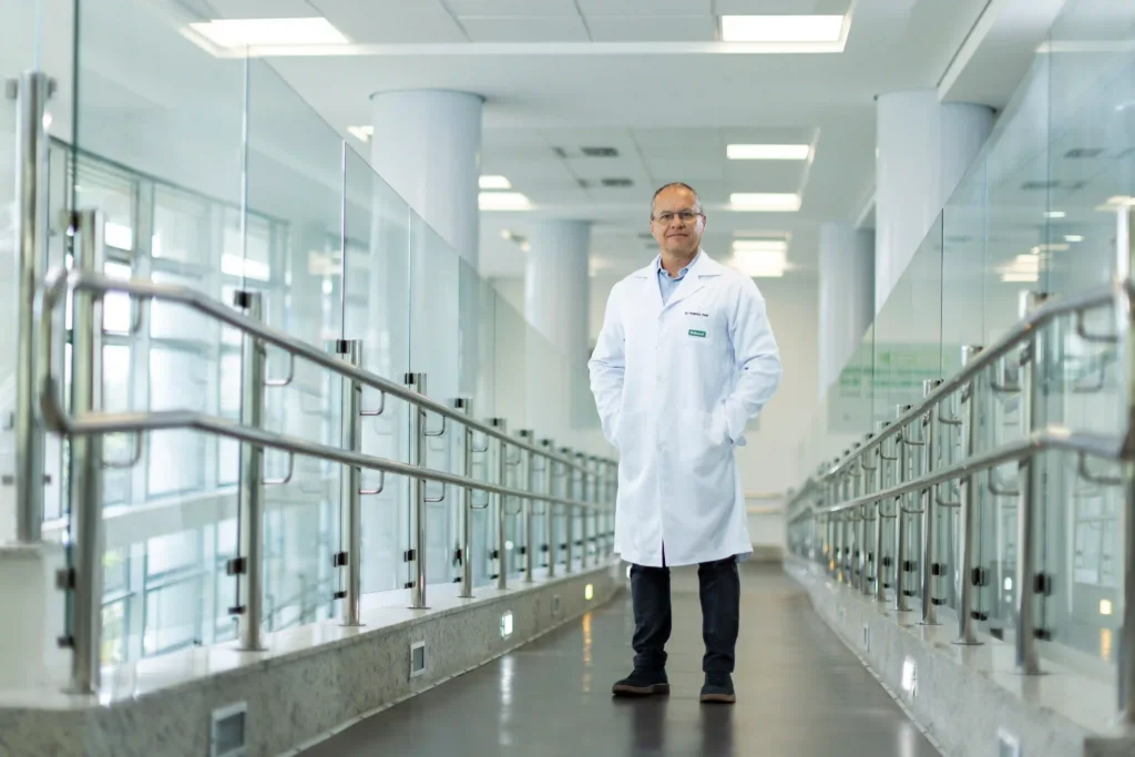 Unimed: médico de jaleco em passarela envidraçada do hospital