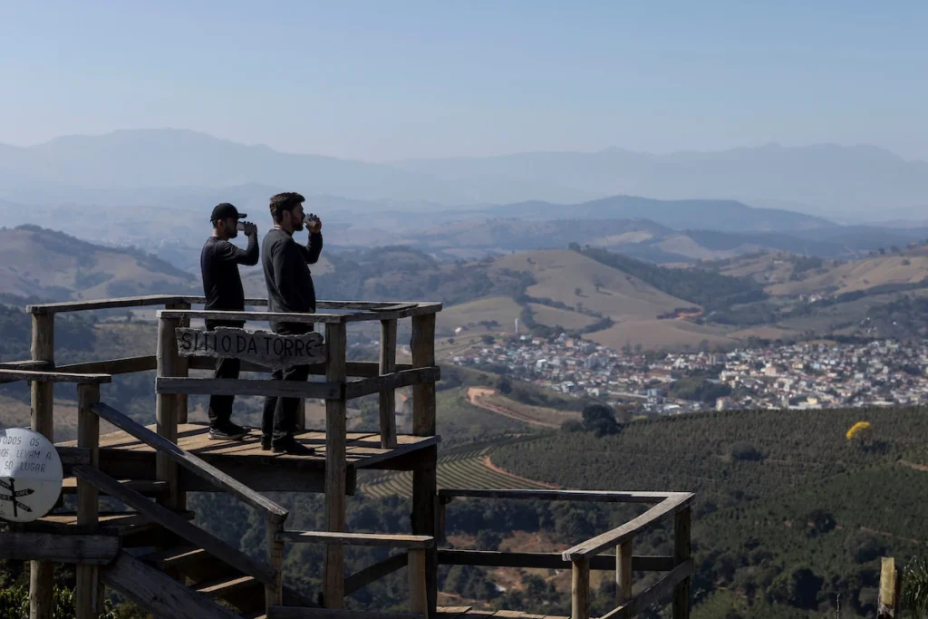 Sebrae Origem e Experiências Turísticas: visitantes no mirante com vista para cidade entre montanhas