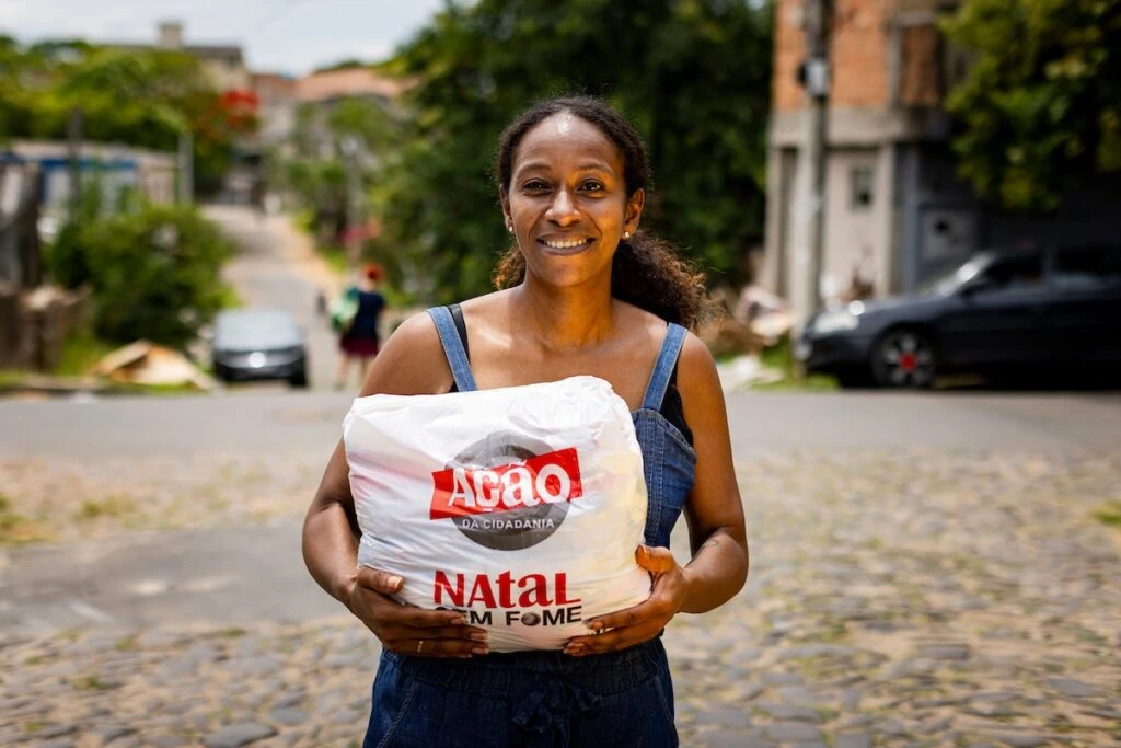 Ação da Cidadania, Natal Sem Fome: mulher sorridente segura sacola de doação