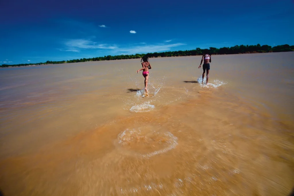 Os Chicos: crianças correm nas águas rasas e barrentas do rio São Francisco