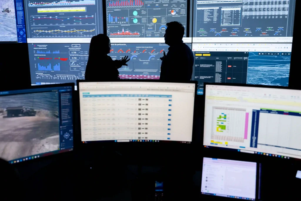 Lundin Mining: silhuetas de profissionais na sala de controle diante de monitores