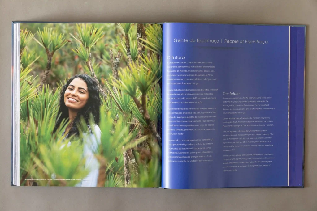 Livro Biodiversidade no Espinhaço Meridional aberto em retrato de mulher entre a vegetação