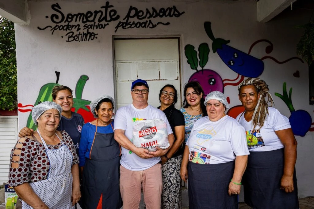 Ação da Cidadania, Natal Sem Fome: equipe da cozinha comunitária posa diante de mural colorido