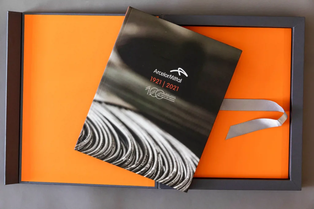 Livro ArcelorMittal 1921–2021 em caixa laranja