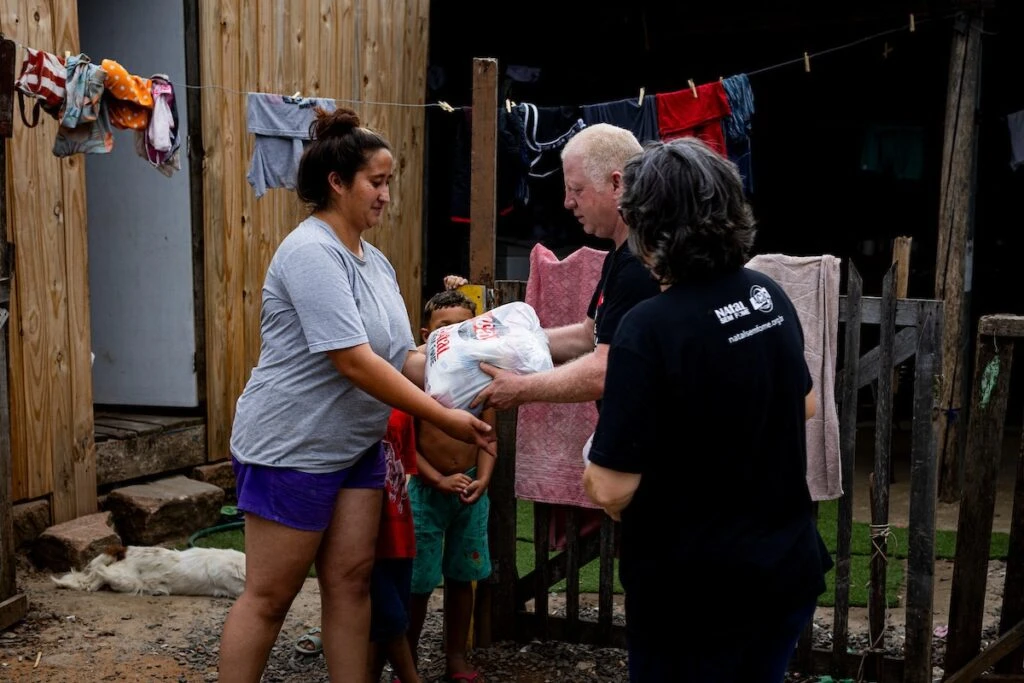 Ação da Cidadania, Natal Sem Fome: voluntária entrega doação a família no portão