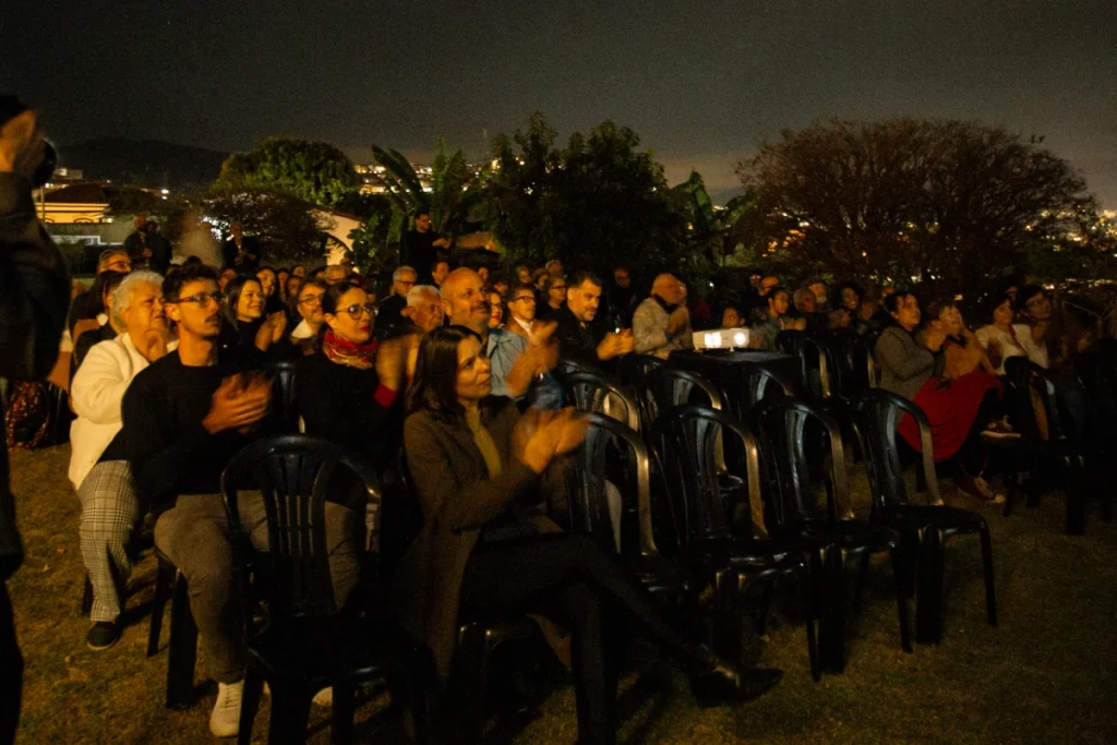 Exibição de Tempo Vário em Mariana: plateia ao ar livre com a cidade ao fundo