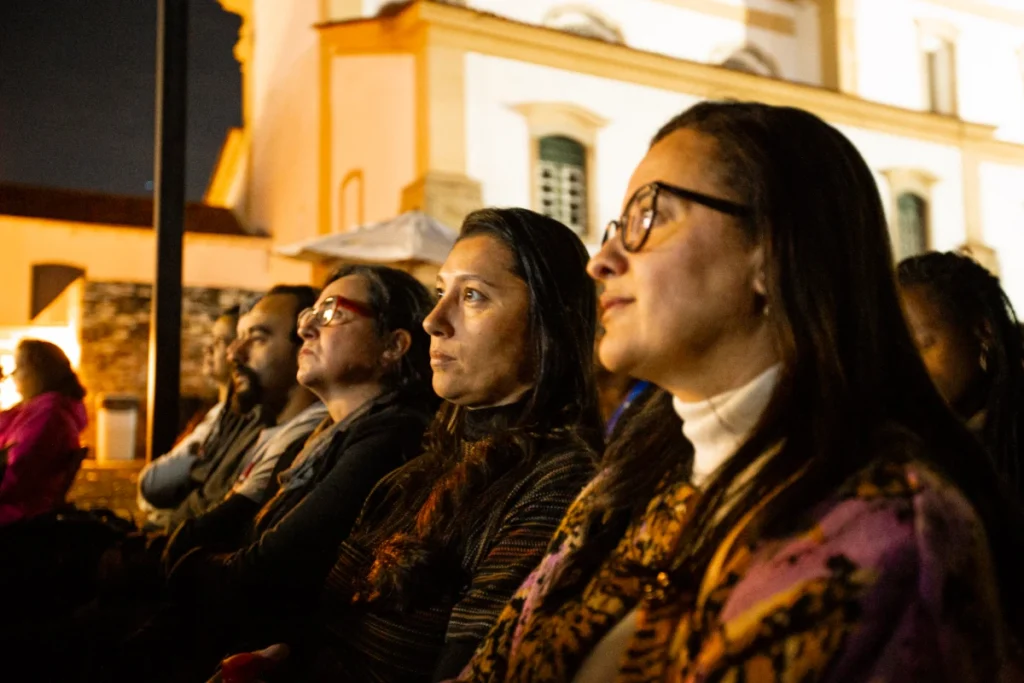 Exibição de Tempo Vário em Mariana: espectadoras atentas à projeção diante de igreja