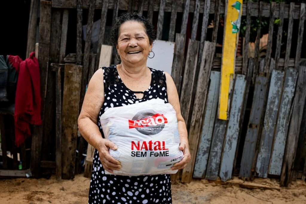 Ação da Cidadania, Natal Sem Fome: senhora sorridente segura sacola de doação