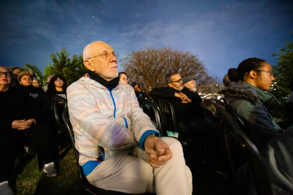 Exibição de Tempo Vário em Mariana: senhor de casaco claro assiste ao filme