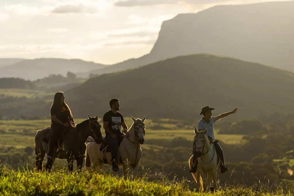 Sebrae Origem e Experiências Turísticas: cavalgada ao entardecer com serra ao fundo