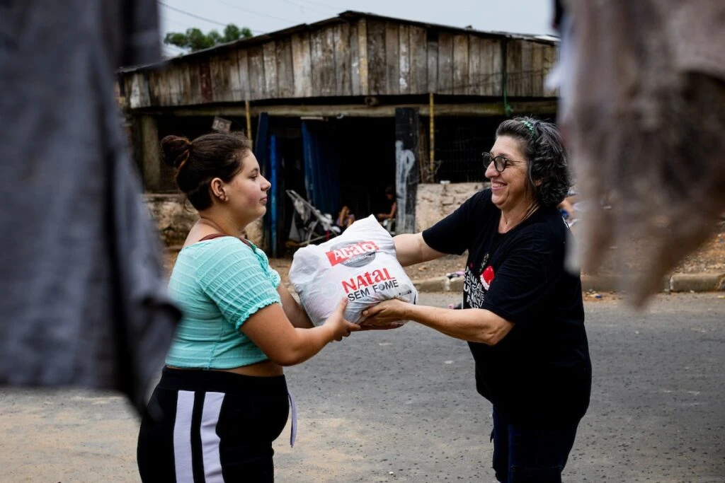 Ação da Cidadania, Natal Sem Fome: voluntária entrega sacola de doação a moradora