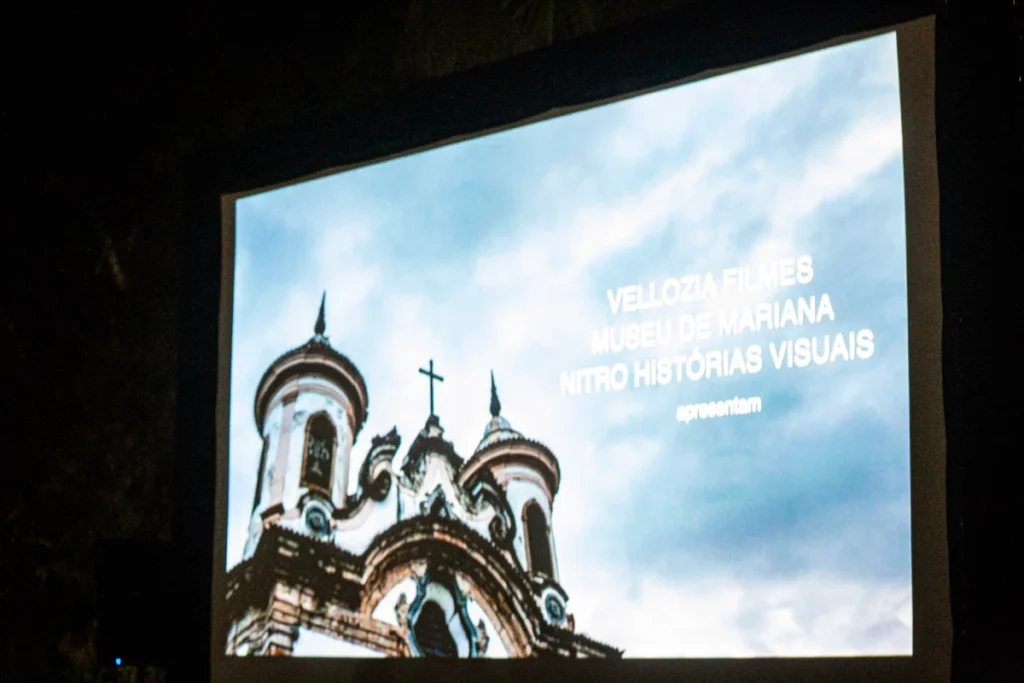 Exibição de Tempo Vário em Mariana: créditos do filme projetados com igreja de Mariana