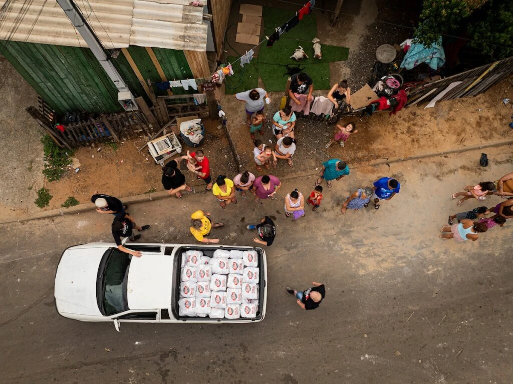 Ação da Cidadania, Natal Sem Fome: moradores se reúnem em torno de picape com doações, vista do alto