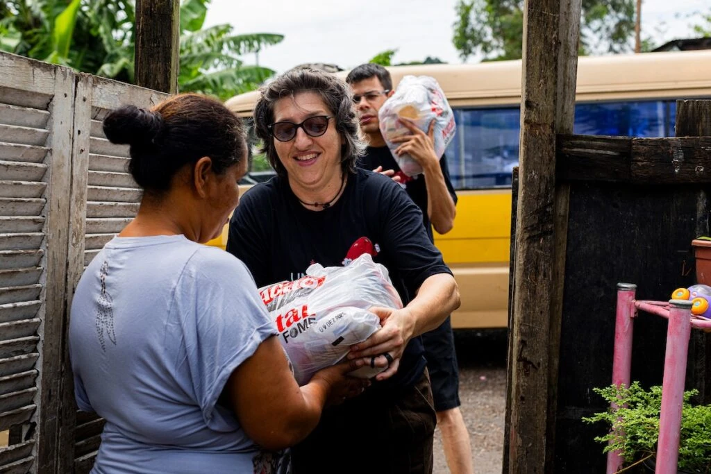 Ação da Cidadania, Natal Sem Fome: voluntária entrega doação sorrindo