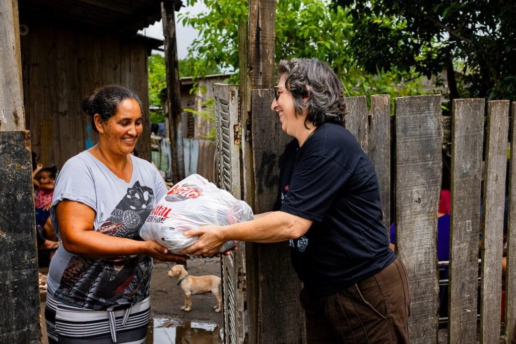 Ação da Cidadania, Natal Sem Fome: voluntária entrega sacola a moradora no portão