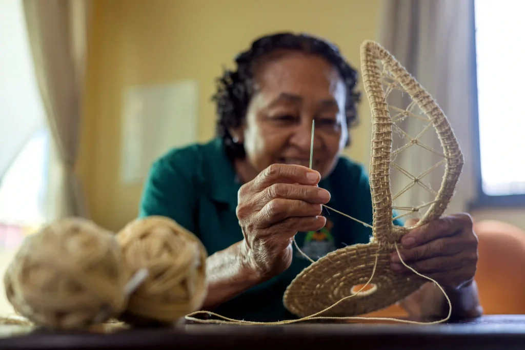 Retratos do Cooperativismo: artesã costura peça de capim dourado