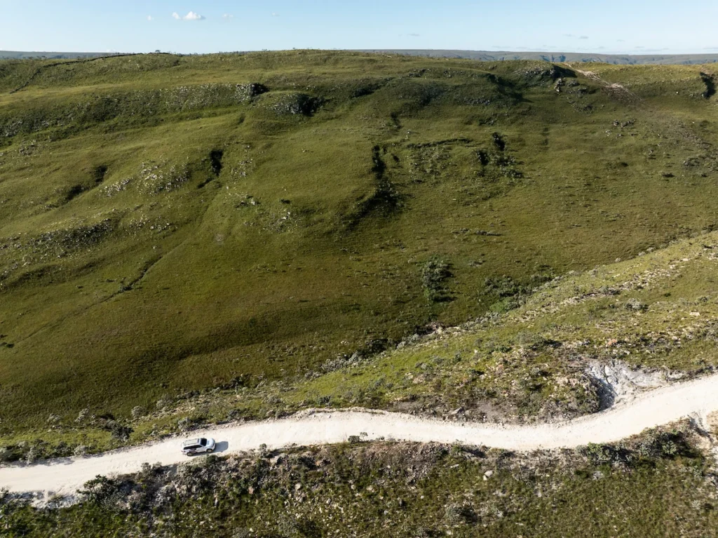 Sebrae Origem e Experiências Turísticas: estrada de terra cortando campos da Serra da Canastra