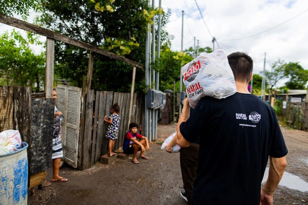 Ação da Cidadania, Natal Sem Fome: voluntário leva sacola no ombro até as casas