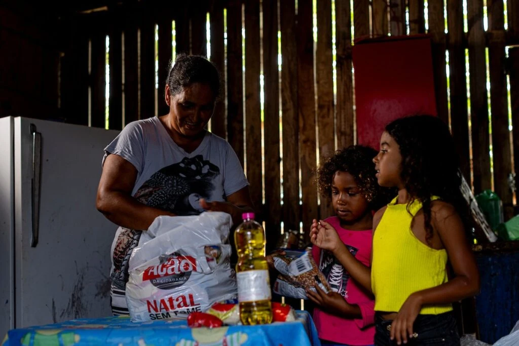 Ação da Cidadania, Natal Sem Fome: mãe e filhas guardam os alimentos recebidos