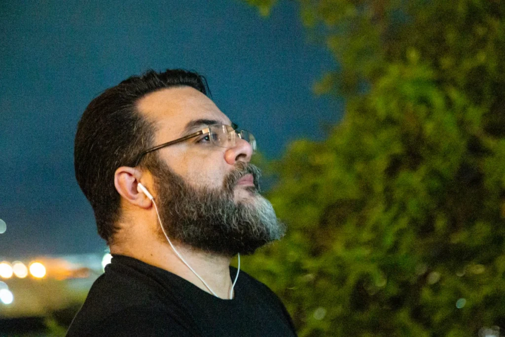 Exibição de Tempo Vário em Mariana: espectador barbado olha para a tela