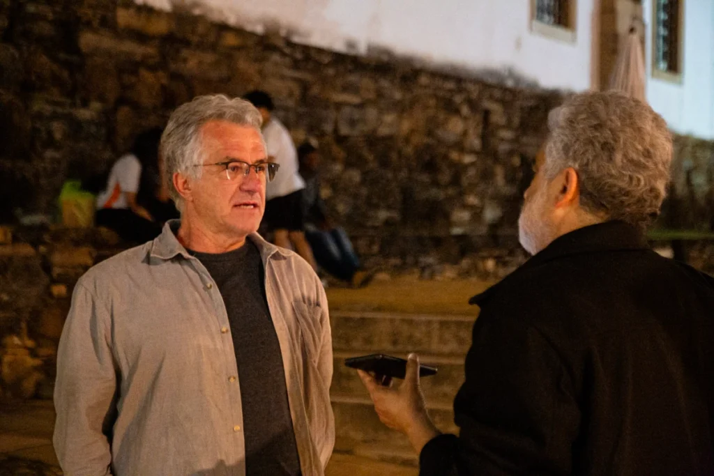 Exibição de Tempo Vário em Mariana: dois homens conversam junto a muro de pedra