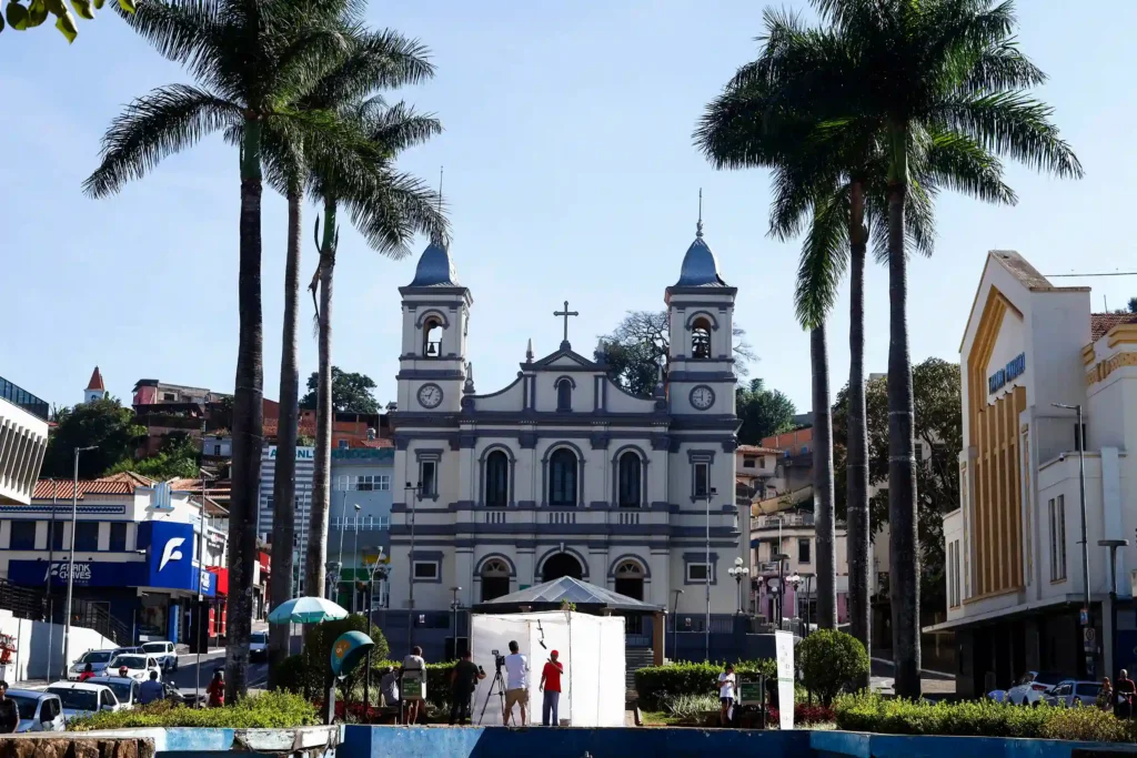 Projeto Moradores: exposição montada em praça diante de igreja histórica com palmeiras