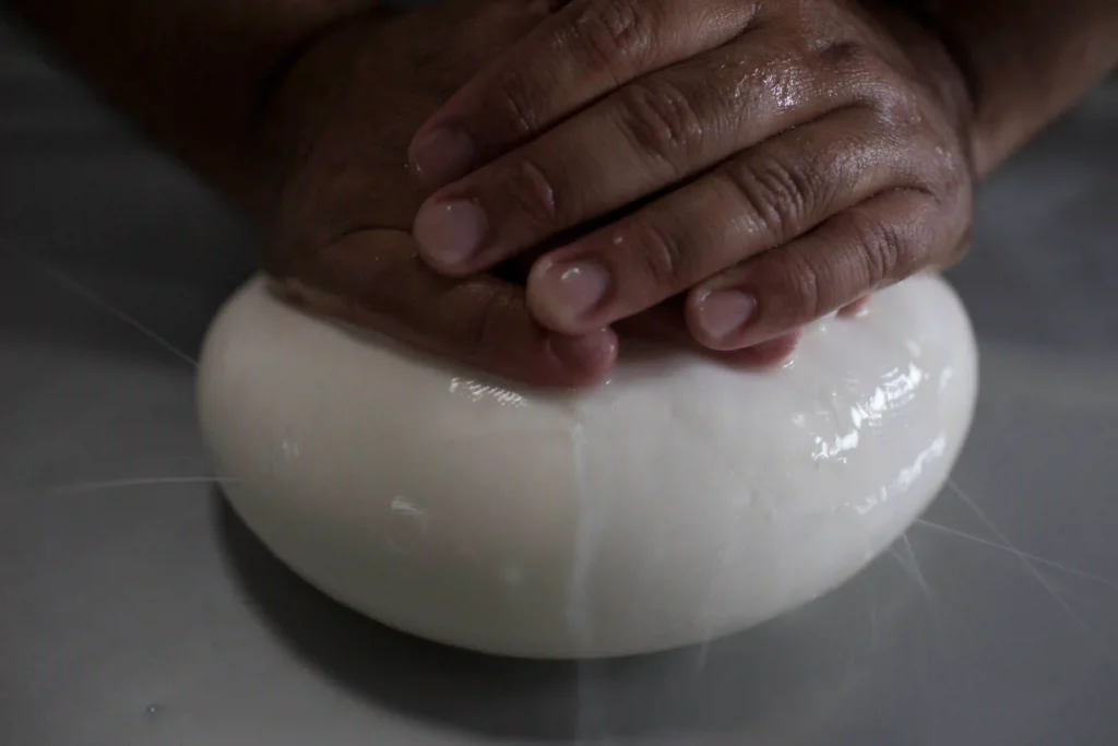 Queijo, Minas Gerais: mãos pressionam a massa do queijo fresco