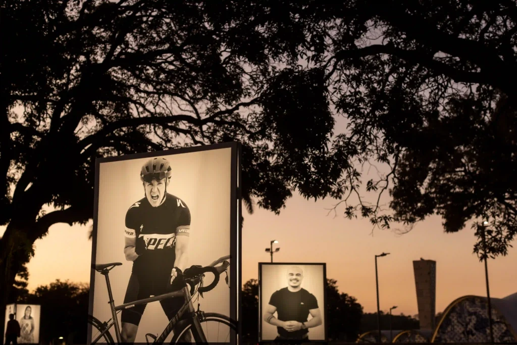 Projeto Moradores: grandes retratos iluminados ao entardecer, um deles de um ciclista