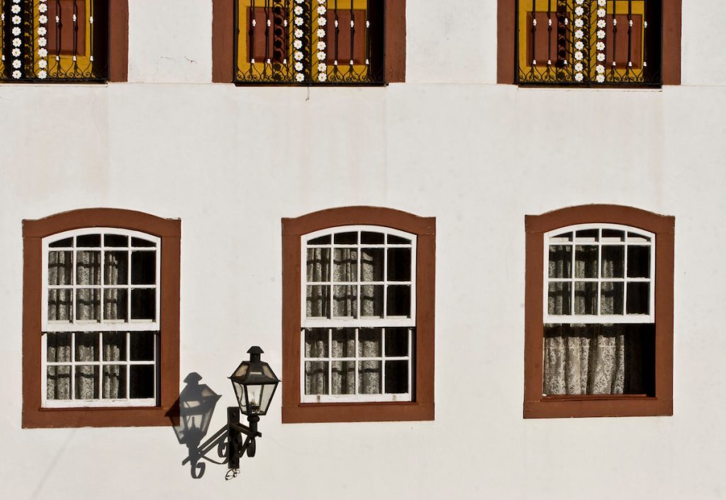 Recordare: janelas coloniais e lampião em fachada branca de casarão em Ouro Preto (MG)