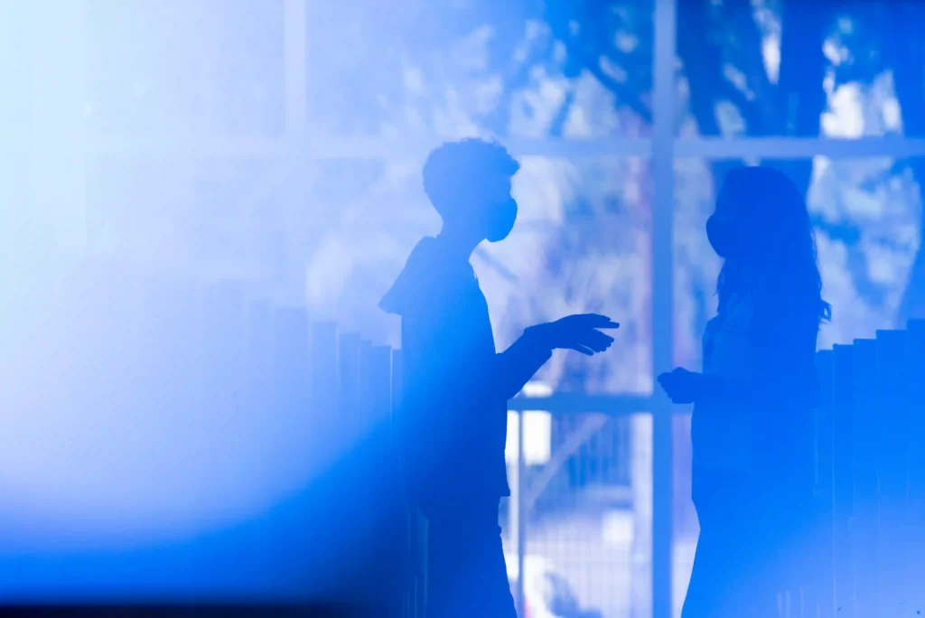 AEC: silhuetas de colaboradores em luz azul