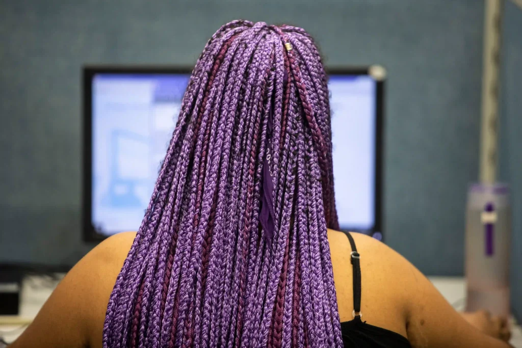 AEC: atendente de tranças roxas diante do computador
